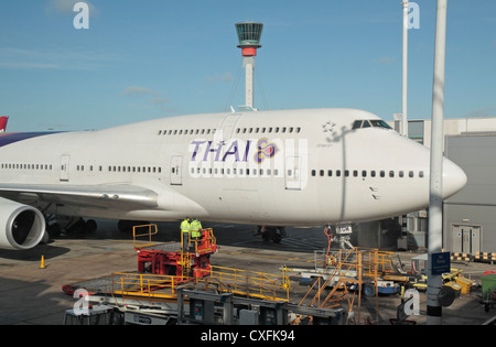 Thai Airways Boeing 747 parcheggiato a un terminale in aeroporto di Heathrow di Londra, Regno Unito. Foto Stock