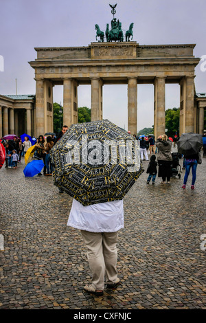 Donna in piedi con un souvenir ombrello di Berlino vicino alla Porta di Brandeburgo Foto Stock