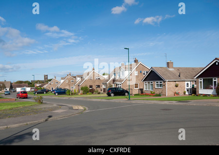 Ben tenuto e bungalows in un tipico degli anni sessanta alloggiamento estate quando le strade e i giardini erano più spaziose di quelle di recente costruzione Foto Stock