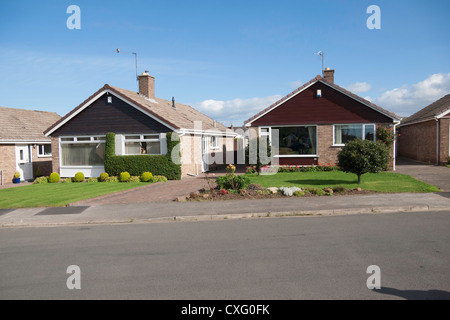 Ben tenuto e bungalows in un tipico degli anni sessanta alloggiamento estate quando le strade e i giardini erano più spaziose di quelle di recente costruzione Foto Stock