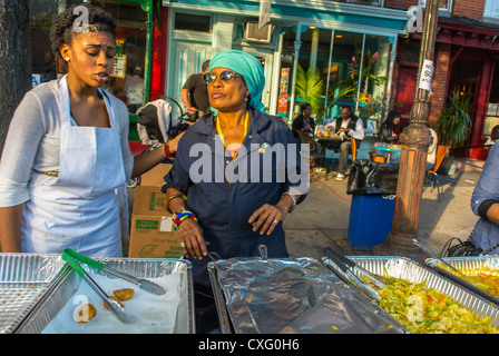 New York City, USA, donne afro-americane che lavorano presso African Street Food Stall, al Brooklyn Festival, 'Atlantic Antic', 'Bedford Stuyvesant' Street Vendor, Senior Employment Foto Stock