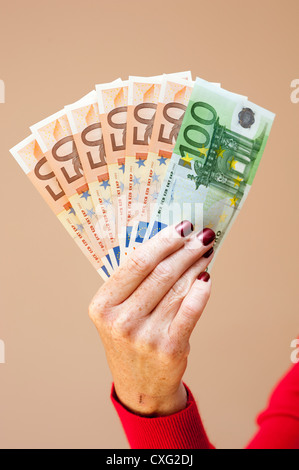 Donna che mantiene la denominazione di grandi dimensioni le banconote in euro in mano Foto Stock