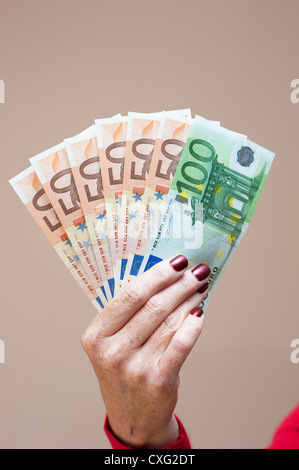 Donna che mantiene la denominazione di grandi dimensioni le banconote in euro in mano Foto Stock
