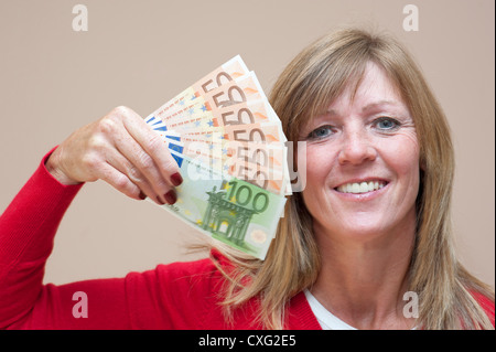 Donna che mantiene la denominazione di grandi dimensioni le banconote in euro in mano Foto Stock