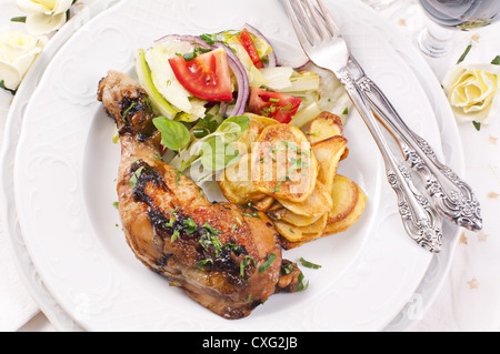 Gamba di pollo alla griglia con patatine e insalata mista Foto Stock