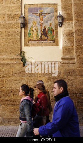 Cadice, la gente a piedi su un murale di Gesù sulla croce sopra Foto Stock