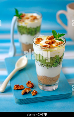 Lo yogurt greco con kiwifruits e noci. Ricetta disponibile. Foto Stock