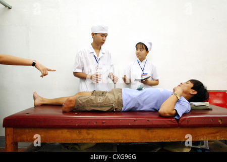 Gli studenti sondaggio una gamba amputato Orthopaedizentrum Saigon Foto Stock