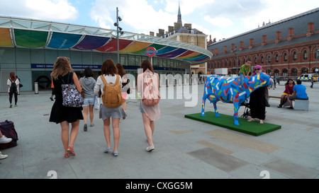 Vista posteriore di giovani donne che indossano zaini camminando verso King Cross Stazione ferroviaria ingresso Londra Inghilterra KATHY DEWITT Foto Stock