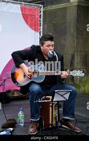 Il cantante e chitarrista con il Public House orchestra suonava in Royal Mile di Edimburgo, Scozia, durante il Festival Fringe. Foto Stock