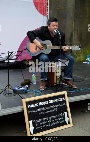 Il cantante e chitarrista con il Public House orchestra suonava in Royal Mile di Edimburgo, Scozia, durante il Festival Fringe. Foto Stock