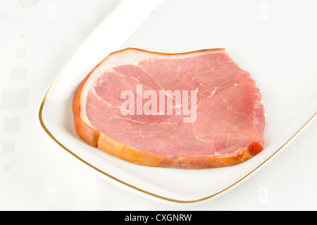 Un raw fumato gammon bistecca su una piastra bianca Foto Stock