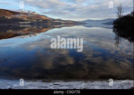 Icy sponde del Loch Tay con distante snow-capped Beinn Ghlas nella gamma Lawers, Killin, Scozia Foto Stock