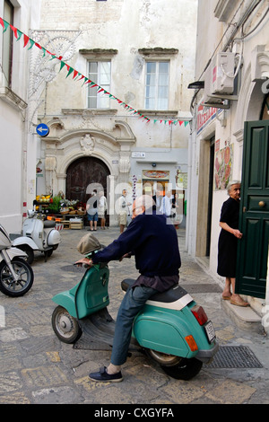 Gallipoli, Puglia, Italia, uomo italiano su scooter in un vicolo Foto Stock