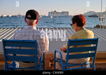 Una coppia di anziani per godere del sole al lungomare di Cannes Foto Stock
