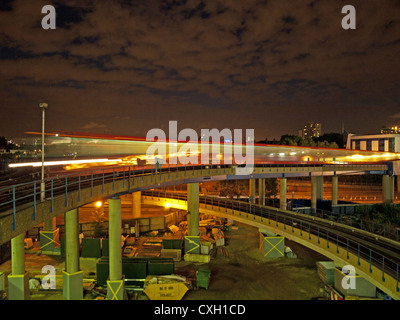 Vista notturna di DLR treno in transito, West India Quay, London, England, Regno Unito Foto Stock