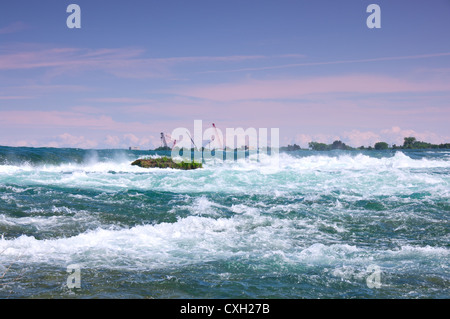 Rapide del Fiume Niagara sopra scende con gru edili vicino internazionale diga di controllo a distanza Foto Stock