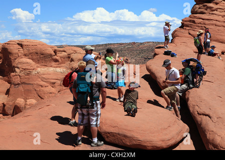 Un grande gruppo di famiglia francese di appoggio per gli escursionisti in cottura sun a Delicate Arch area nel Parco Nazionale di Arches, Utah, Stati Uniti d'America Foto Stock