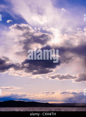 Tramonto dal paesaggio porpora visto attraverso le nuvole drammatiche, le Palisades nella contea di Rockland attraverso il fiume Hudson da Senasqua Park Croton-on-Hudson NY Foto Stock