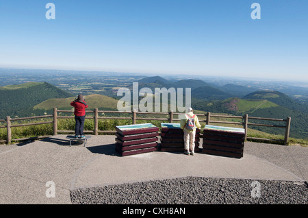 I turisti guardando la vista sul paesaggio vulcanico della Chaine des Puys, Auvergne, Francia Foto Stock