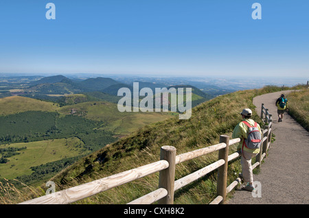 Escursionista guardando la vista dal Puy-de-Dome sul paesaggio vulcanico della Chaine des Puys, Auvergne, Francia. Foto Stock