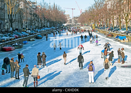 Pattinaggio su ghiaccio sui canali di Amsterdam Paesi Bassi in inverno Foto Stock