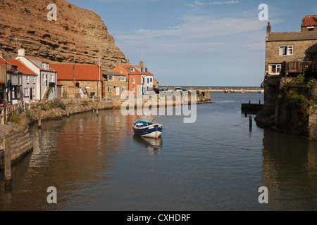 Barca da pesca nel villaggio di Staithes e il suo porto vista dal ponte sul Beck Staithes North Yorkshire Regno Unito Foto Stock