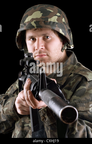 Soldato in possesso di una pistola in studio Foto Stock