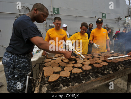 Marinai e marines godono di un acciaio picnic sulla spiaggia a bordo distribuita Amphibious Assault nave USS bonhomme richard (LHD 6). bonhomme richard è la nave di piombo del solo distribuita anfibio gruppo pronto ed è operante negli Stati Uniti 7 flotta area di responsabilità. Foto Stock