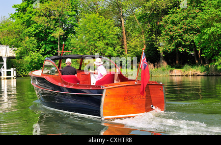 Due uomini che navigano su un motoveyacht da Signore, sulle alte rive del Tamigi, Pangbourne, Berkshire, Inghilterra, Regno Unito Foto Stock