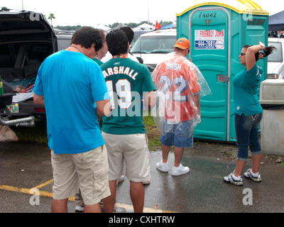 Delfini di Miami fan stand in linea per una temporanea i bagni portatili miami florida usa Foto Stock