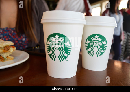 Due prendono il via le tazze di Starbucks su un tavolo Foto Stock