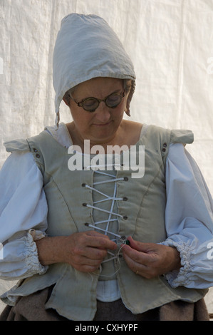 Una donna di cucitura, vestito nel XVII secolo e in stile. Ella è con Lord Hopton il reggimento di Foote, guerra civile inglese gruppo di rievocazione. Il Dorset, Inghilterra, Regno Unito. Foto Stock