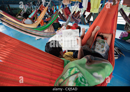 Passeggeri dormire in amache in una barca fluviale sul fiume del Amazon, Perù. Foto Stock