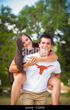 Stati Uniti d'America, Texas, ragazzo adolescente dando sovrapponibile alla ragazza adolescente, sorridente, ritratto Foto Stock