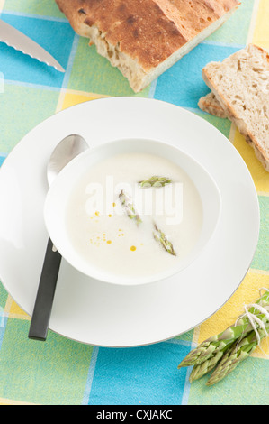 Miscelati cremosa zuppa di asparagi guarnita con asparagi verdi servita con pane Foto Stock