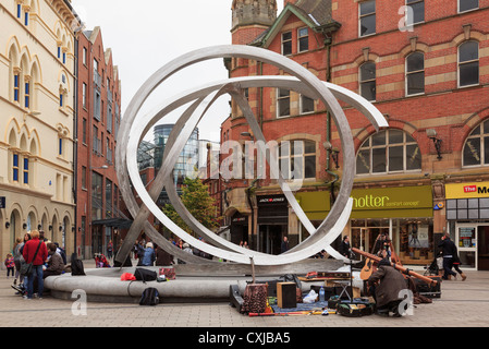 Scena di strada da spirito di Belfast scultura in acciaio da Dan George, soprannominato anelli di cipolla in Arthur Square Belfast Irlanda del Nord Foto Stock