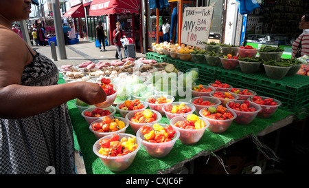 Donna che acquista peperoni rossi caldi Scotch Bonnet Peperoncini chilis Market stalla a Walthamstow High Street, East London Inghilterra Regno Unito KATHY DEWITT Foto Stock