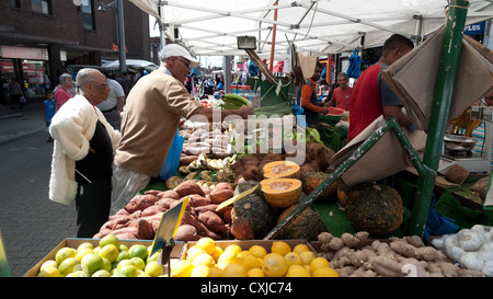 Una coppia di anziani shopping per frutta e verdura in un mercato in stallo Walthamstow High Street, East London Inghilterra England Regno Unito Foto Stock