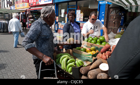 Le donne lo shopping per frutta e verdura in un mercato in stallo Walthamstow High Street, East London Inghilterra England Regno Unito Foto Stock