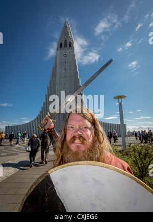 Viking con spada e scudo, Reykjavik del festival culturale( Menningarnott) Chiesa Hallgrimskirkja in background, Islanda Foto Stock