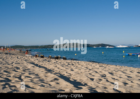 Il turista a godere la sabbiosa spiaggia di Pampelonne nel sud della Francia vicino a St Tropez. barche di lusso sono ormeggiate nella baia. Foto Stock