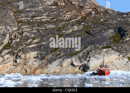 Barca da pesca nel ghiaccio soffocato Harbour di Discoteca Bay a Ilulissat a metà estate. Il ghiaccio è in porto l'anno. Foto Stock