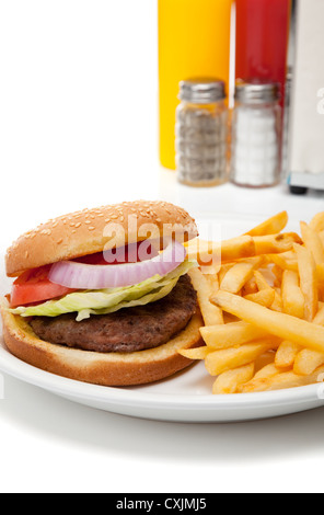 Hamburger e patatine fritte su un tavolo con sale e pepe, senape, ketchup e tovaglioli Foto Stock