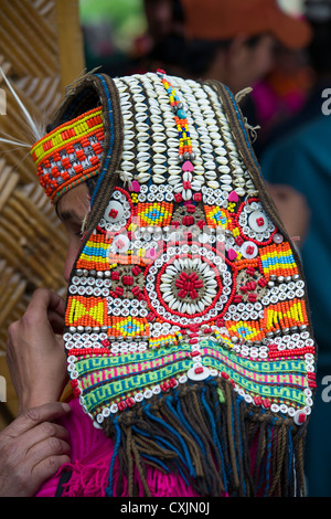 Kalash donna che indossa un cowrie guscio copricapo (shushut) presso il Joshi (Festa della Primavera), Rumbur Valley, biglietto, Khyber-Pakhtunkhwa, Pakistan Foto Stock