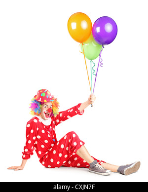 Sorridente seduta clown e palloncini di contenimento isolato su sfondo bianco Foto Stock