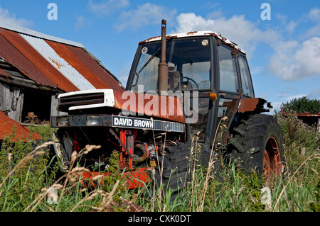 Vecchio trattore David Brown abbandonato arrugginito macchine agricole vicino a un fienile Inghilterra Regno Unito Regno Unito Gran Bretagna Foto Stock