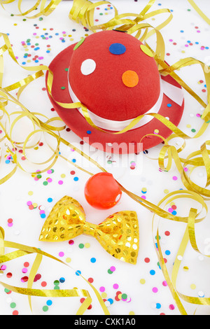 Accessori in costume di Carnevale isolati con sfondo colorato. Cappello  rosa con bicchieri verdi, naso rosso pagliaccio, piume gialle e ruscelli  colorati Foto stock - Alamy