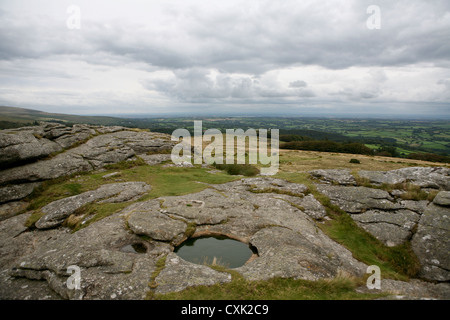 Vista di grande portata dalla cima del Kestor Rock, con bacino di roccia riempito d'acqua / piscina in primo piano, Dartmoor National Park, Regno Unito Foto Stock