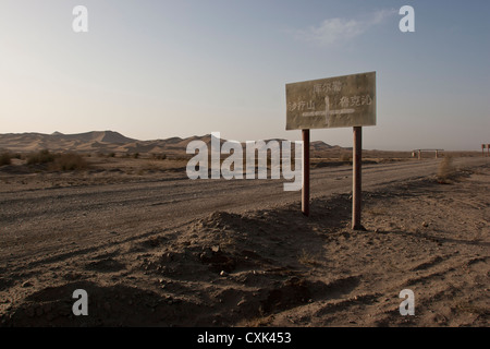 Un segno su un deserto di strada sterrata in Xinjiang, Cina Foto Stock